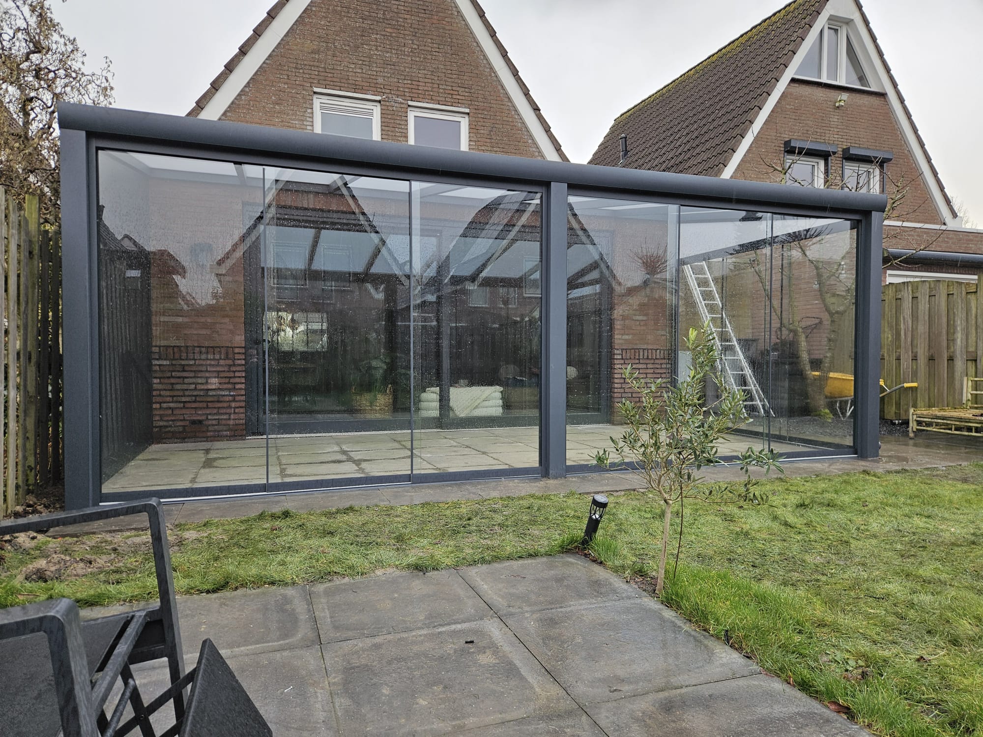 Aluminium terrasoverkapping met glazen dak aan een woning