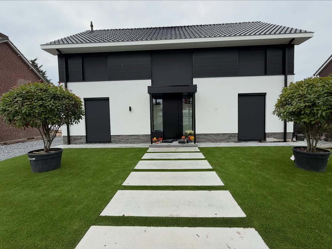 Moderne witte villa met antracietkleurige rolluiken, geplaatst door JVL Zonweringen