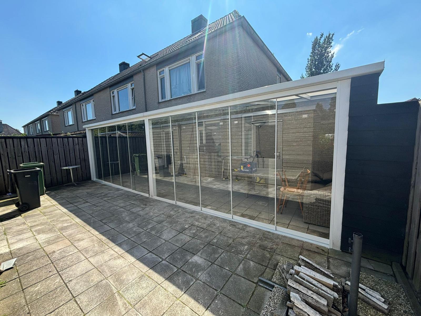 Glazen schuifwanden onder een veranda, volledig gesloten