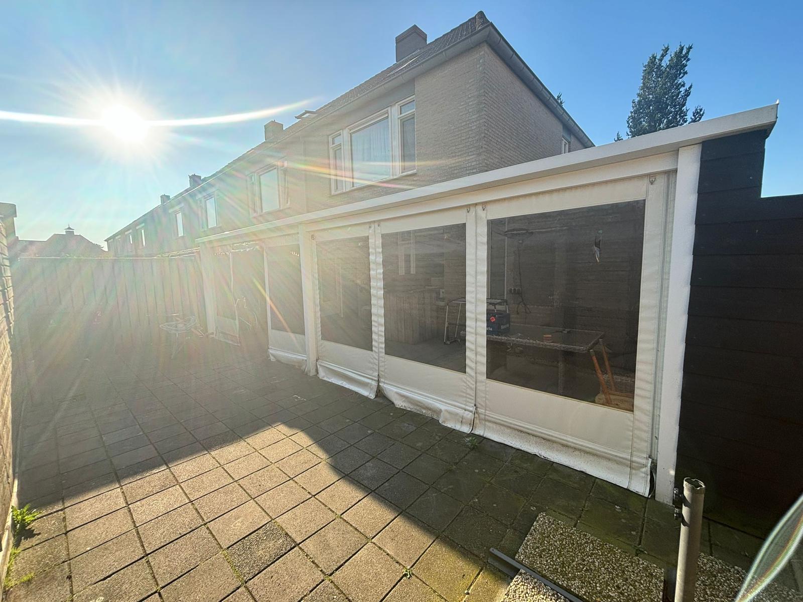 Veranda met glazen schuifwanden in de avondzon