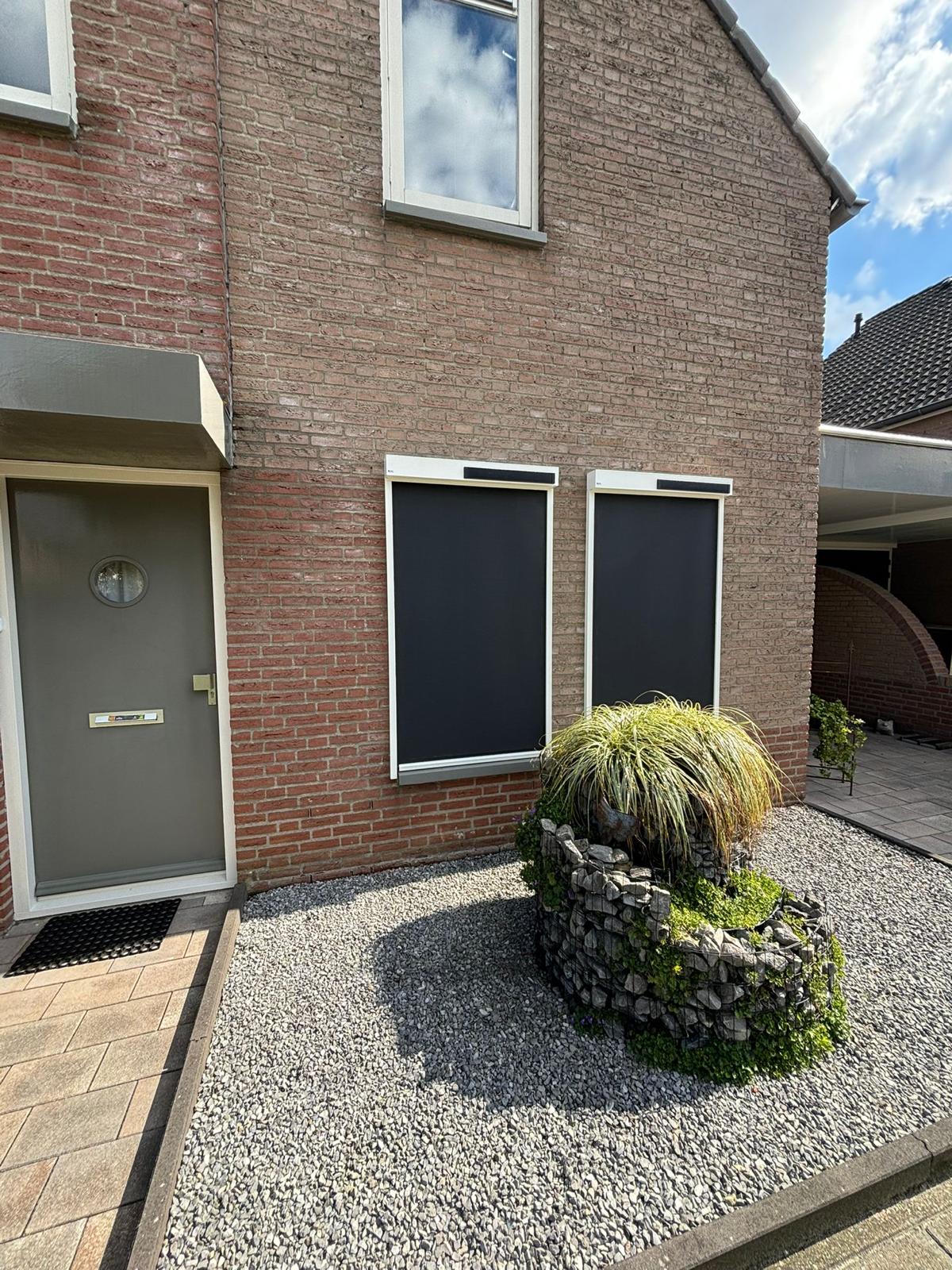 Zwarte screens op een woning met tuin